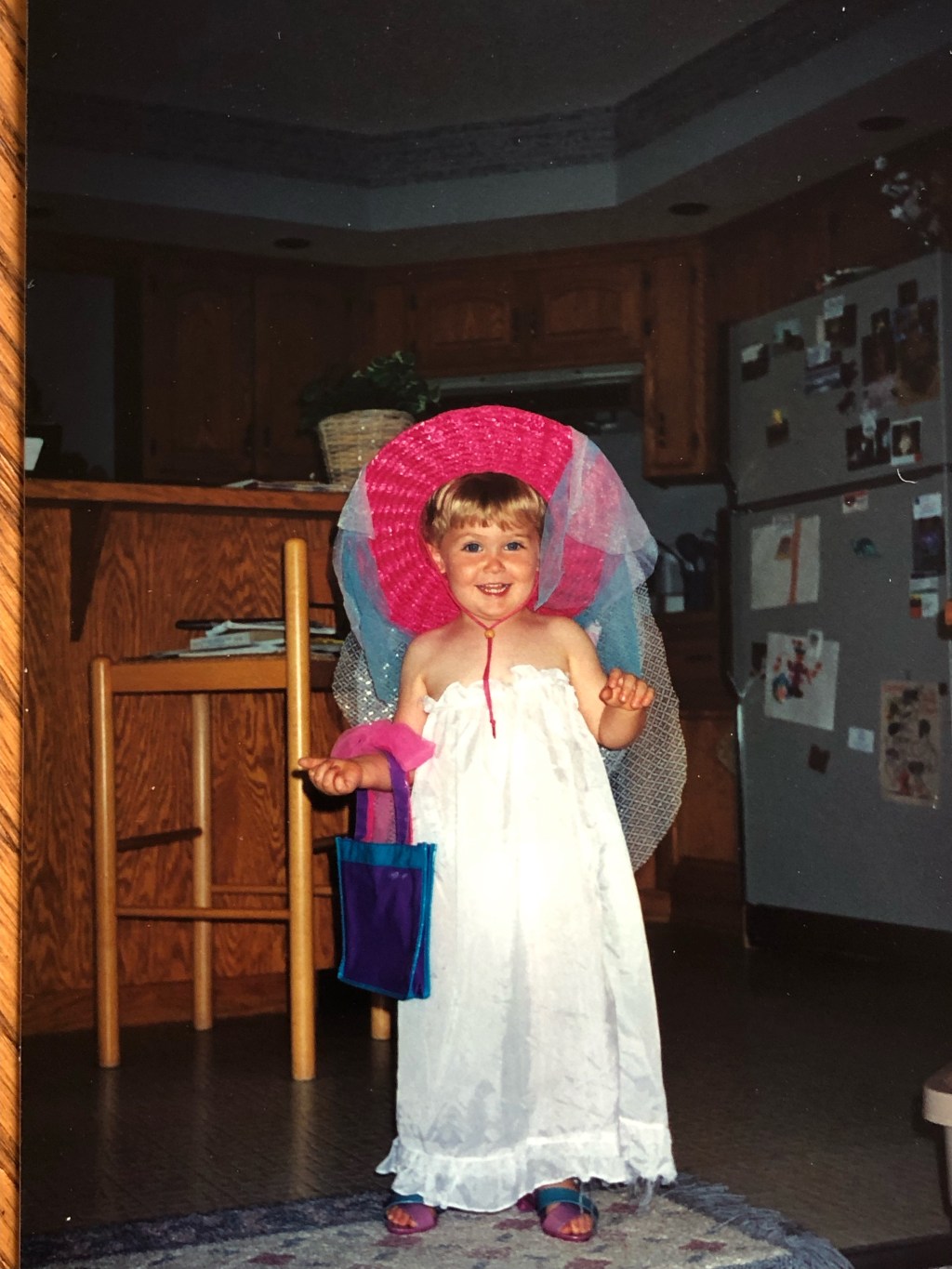 Dielle Lundberg, a white child playing dress-up in a pink hat and white dress while growing-up in Minnesota